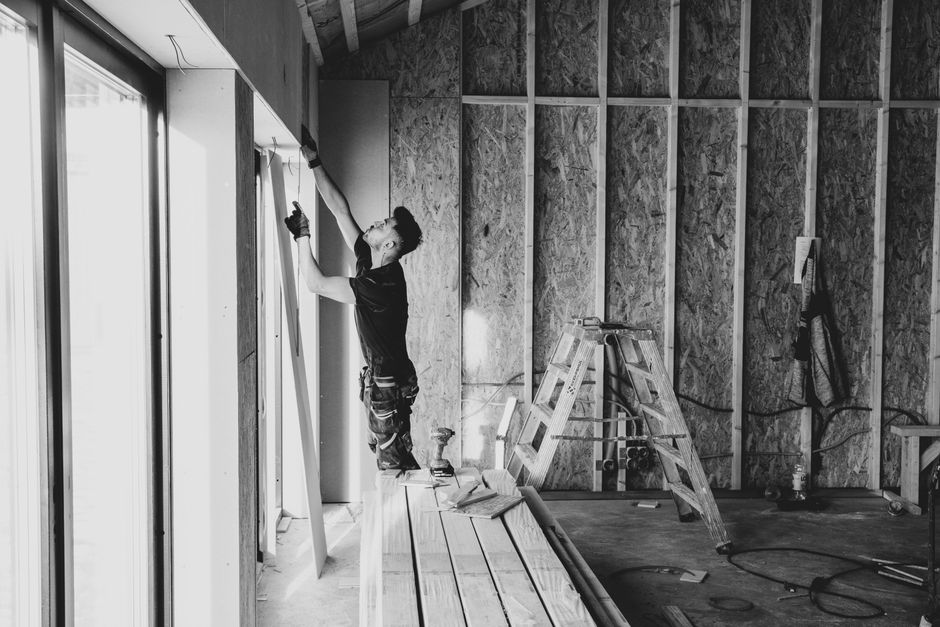 Contractor carefully installing premium window treatments in a residential home